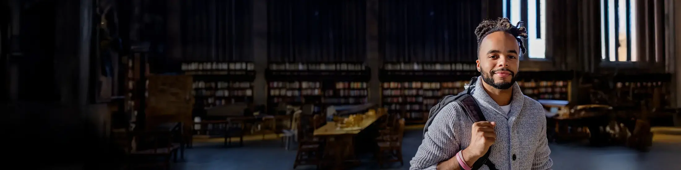 Male student leaving the library after studying. 